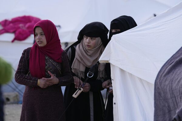 Girls made homeless by the devastating earthquakes stand outside a tent looking for aid distribution at a shelter camp in Killi, Syria on Sunday 12 February 2023. - Sputnik International