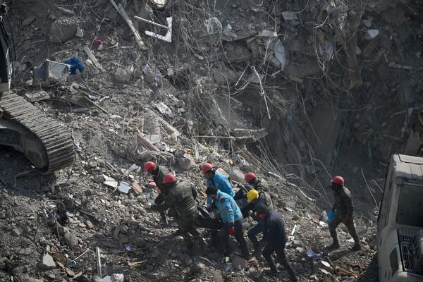 Search and rescue teams drag a body from the rubble of collapsed buildings in Kahramanmaras on 14 February 2023, a week after an earthquake devastated parts of Turkiye and Syria leaving more than 36,000 dead and millions in dire need of aid. - Sputnik International