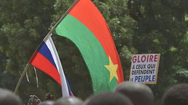 Russian and a Burkina Faso flags are waved by a crowd of protesters gathered for a demonstration in Ouagadougou on October 2, 2022. - Sputnik International