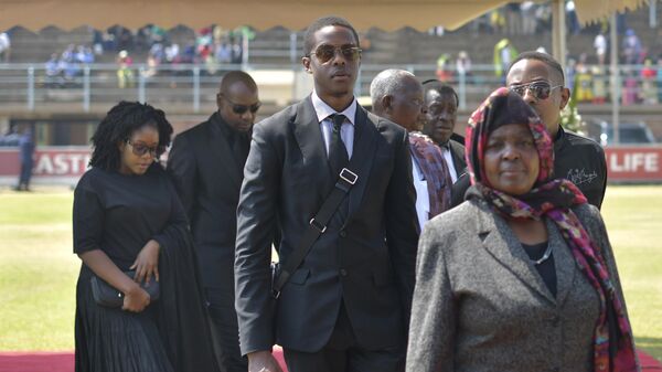 The children of Zimbabwe's former president, the late Robert Mugabe, Robert Junior (C), Chatunga (R-partially obscured) and Bona (L) arrive at Rufaro Stadium on September 13, 2019, where the body of Mugabe lay in state for a second day - Sputnik International