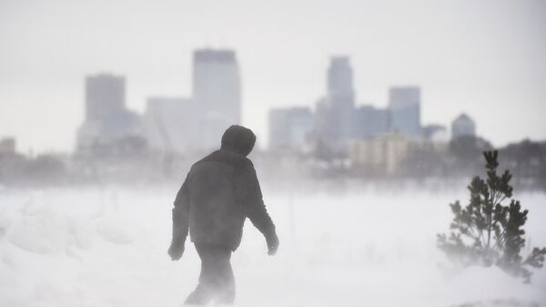  A man goes for a walk in front of the Minneapolis skyline at Bde Maka Ska Park during a snowstorm in Minneapolis, Minnesota, on February 22, 2023. - Sputnik International