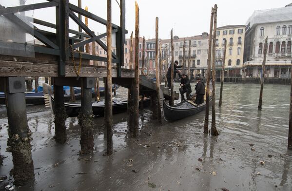 Passengers get off a gondola docked along a canal during a low tide in Venice, Italy. Some of Venice&#x27;s secondary canals have practically dried up lately due a prolonged spell of low tides linked to a lingering high-pressure weather system.  - Sputnik International