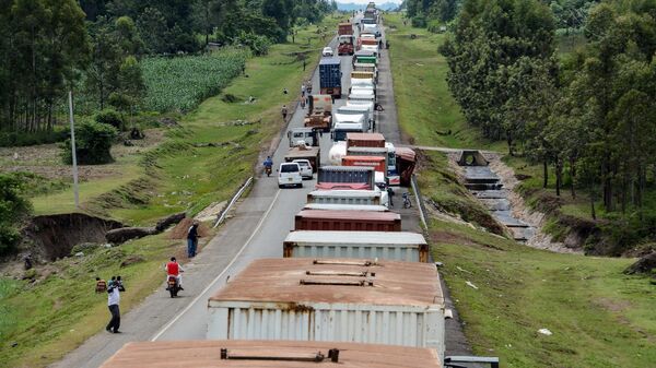 Trucks wait in a line on the road to enter Uganda in Malaba, a city bordering with Uganda, western Kenya, on April 29, 2020 - Sputnik International