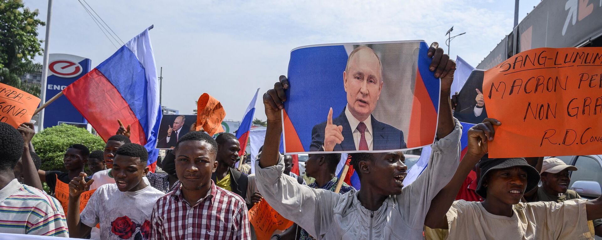 Protesters waving Russian flags and holding a portrait of Russian President Vladimir Putin gather in front of the French Embassy in Kinshasa on March 1, 2023 for a demonstration against the visit to the Democratic Republic of Congo of French President Emmanuel Macron - Sputnik International, 1920, 01.03.2023