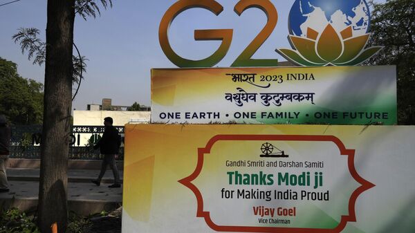 A commuter walks past a G20 logo at a crossing in New Delhi, India, Tuesday, Feb. 28, 2023. - Sputnik International