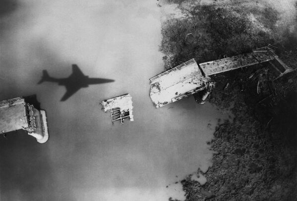 Тень американского самолета RF-101, пролетающей над мостом Май Дуо, разрушенным американскими обстрелами, в Северном Вьетнаме, сделанная в апреле 1965 года - Sputnik International