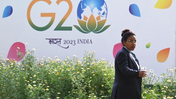 A security personnel gestures beside a hoarding during the G20 Foreign Minister’s meeting in New Delhi on March 2, 2023 - Sputnik International
