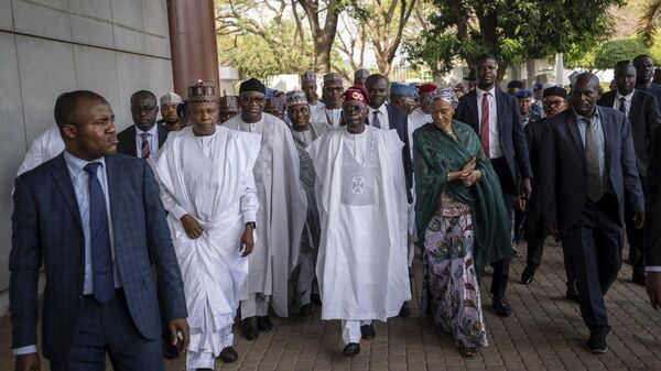 President-Elect Bola Tinubu, center, walks with his wife Oluremi Tinubu, center right, to receive his certificate at a ceremony in Abuja, Nigeria, Wednesday, March 1, 2023. Election officials declared Tinubu the winner of Nigeria's presidential election Wednesday, keeping the ruling party in power in Africa's most populous nation. - Sputnik International