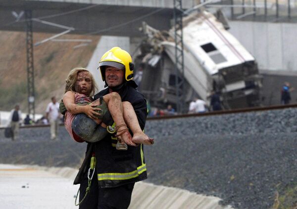 A train hurtled off the tracks on 24 July 2013, in north-west Spain, killing at least 78 passengers and injuring more than 140. Our picture shows a fireman carrying an injured young girl after the accident near the city of Santiago de Compostela. - Sputnik International