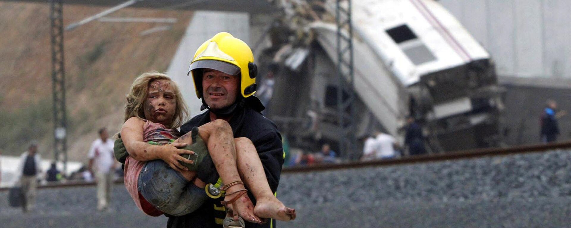 A picture taken on July 24, 2013 shows a fireman carrying an injured young girl following a train accident near the city of Santiago de Compostela.  - Sputnik International, 1920, 04.03.2023