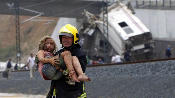 A picture taken on July 24, 2013 shows a fireman carrying an injured young girl following a train accident near the city of Santiago de Compostela.  - Sputnik International