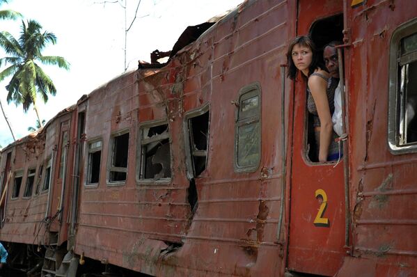 Visitors look out from inside the wrecked coach of the Queen of the Sea, a train that was swept away by giant waves of the tsunami at Peraliya, Sri Lanka on Sunday, 20 February 2005. - Sputnik International