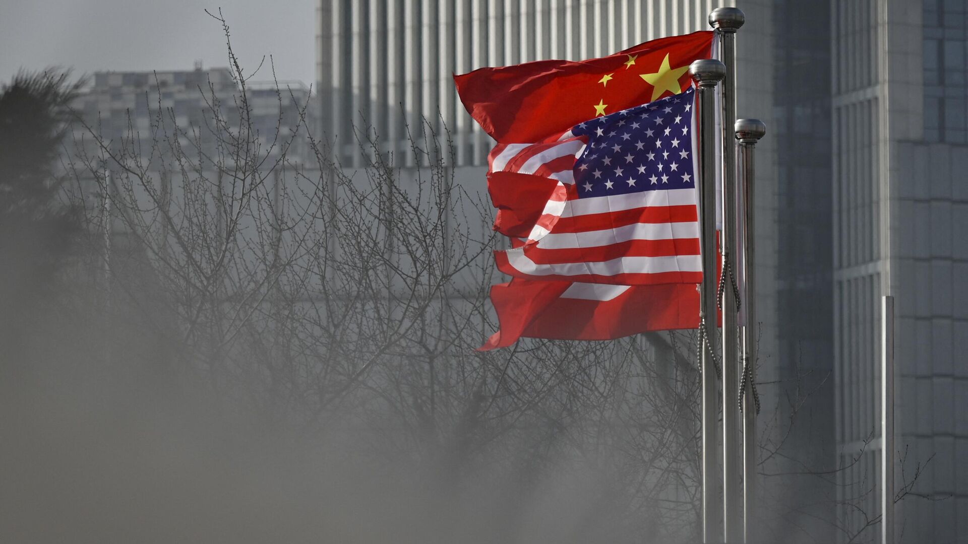 Chinese and US national flags flutter at the entrance of a company office building in Beijing on January 19, 2020 - Sputnik International, 1920, 08.03.2023
