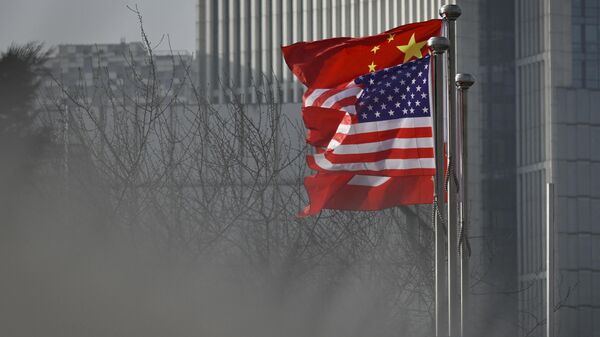 Chinese and US national flags flutter at the entrance of a company office building in Beijing on January 19, 2020 - Sputnik International