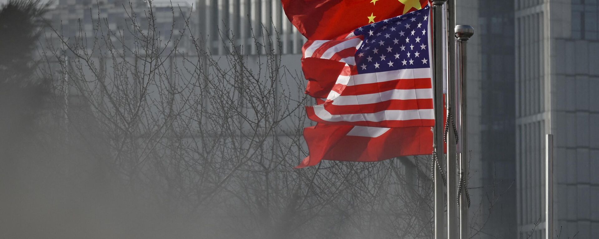 Chinese and US national flags flutter at the entrance of a company office building in Beijing on January 19, 2020 - Sputnik International, 1920, 08.03.2023