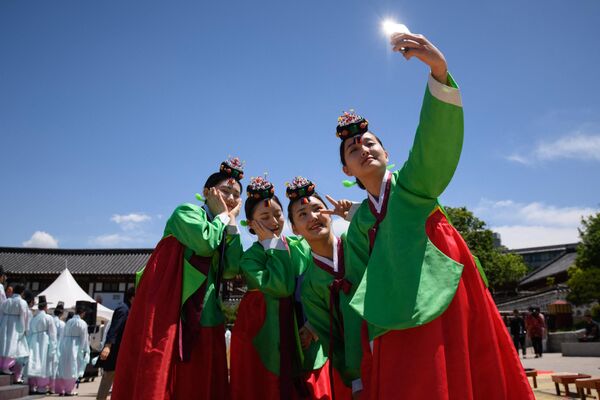 Young women wearing traditional hanbok dress pose for a photo following a traditional Coming-of-Age Day ceremony to mark adulthood in Seoul, South Korea.  The Coming-of-Age Day marks age 19, at which a person is legally able to make life choices like voting. - Sputnik International