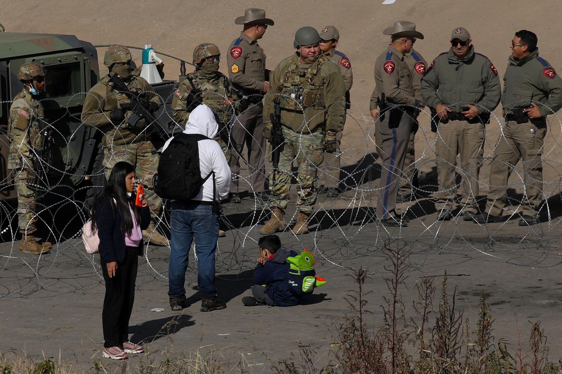 Migrants seeking asylum in the United States ask Texas National Guard agents to let them turn themselves in with Border Patrol agents in the El Paso, Texas, US. border with Ciudad Juarez, Chihuahua state, Mexico, on December 20, 2022 - Sputnik International, 1920, 08.03.2023
