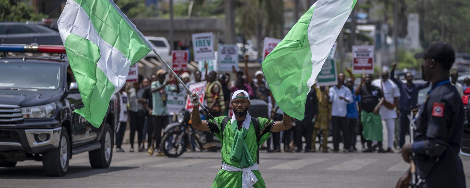 A demonstrator holds two Nigerian flags as he and others accusing the election commission of irregularities and disenfranchising voters make a protest in downtown Abuja, Nigeria, Tuesday, Feb. 28, 2023. - Sputnik International, 1920, 09.03.2023