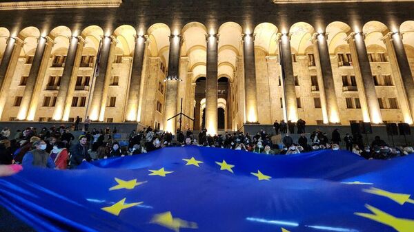 Protesters unfurl European Union flag before the parliament building in downtown Tbilisi. March 7, 2023. - Sputnik International