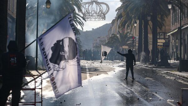 Protesters hold flags of Corsica as they face CRS riot police in Ajaccio on April 3, 2022. - Sputnik International