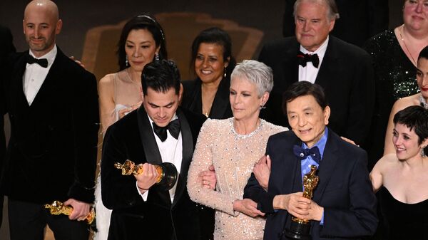 US film producer Jonathan Wang (C) accepts the Oscar for Best Picture for Everything Everywhere All at Once alongside US actress Jamie Lee Curtis onstage during the 95th Annual Academy Awards at the Dolby Theatre in Hollywood, California on March 12, 2023.  - Sputnik International