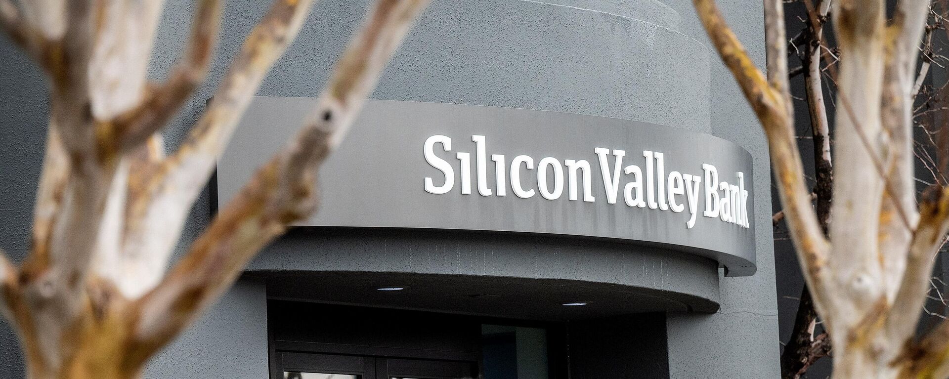 A pedestrian speaks on a mobile telephone as he walks past Silicon Valley Bank’s headquarters in Santa Clara, California on March 10, 2023. - Sputnik International, 1920, 13.03.2023