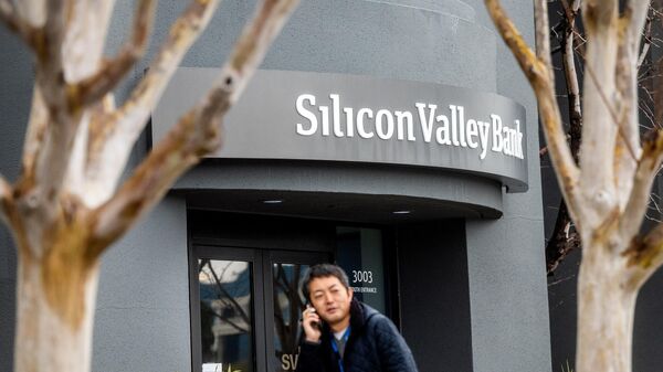 A pedestrian speaks on a mobile telephone as he walks past Silicon Valley Bank’s headquarters in Santa Clara, California on March 10, 2023. - Sputnik International