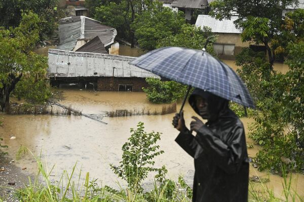 A man passes houses that are submerged in flood waters in Blantyre, Malawi Tuesday, March 14, 2023. - Sputnik International