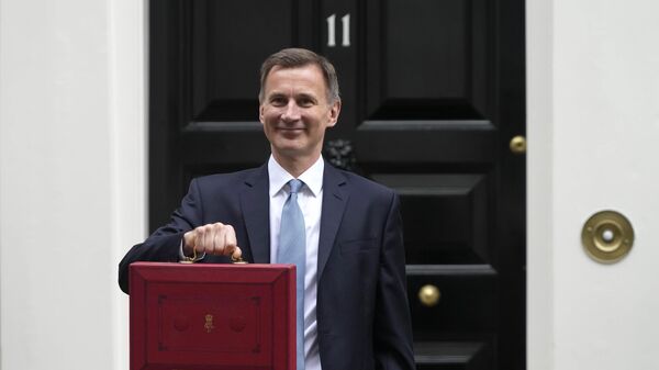 Britain's Chancellor of the Exchequer Jeremy Hunt poses for the media with his traditional Red despatch box as he leaves 11 Downing Street for the House of Commons to deliver the Budget - Sputnik International