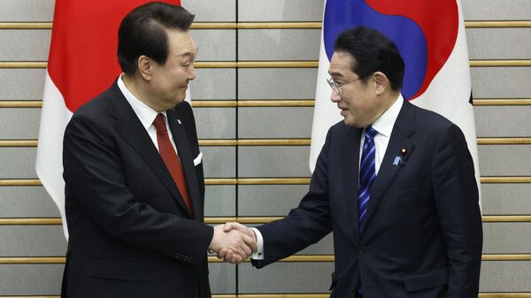 South Korea's President Yoon Suk Yeol (L) and Japan's Prime Minister Fumio Kishida shake hands ahead of a summit meeting at the prime minister's official residence in Tokyo on 16 March 2023 - Sputnik International