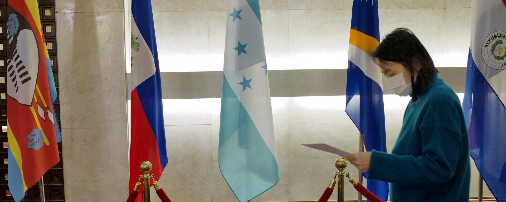 A woman walks past a Honduras flag (C) at Taiwan’s Ministry of Foreign Affairs in Taipei on March 15, 2023.  - Sputnik International, 1920, 26.03.2023