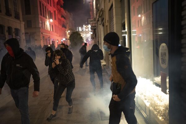 People run from tear gas fired by French riot police during a demonstration in Marseille in the south of France on Thursday 16 March 2023. - Sputnik International