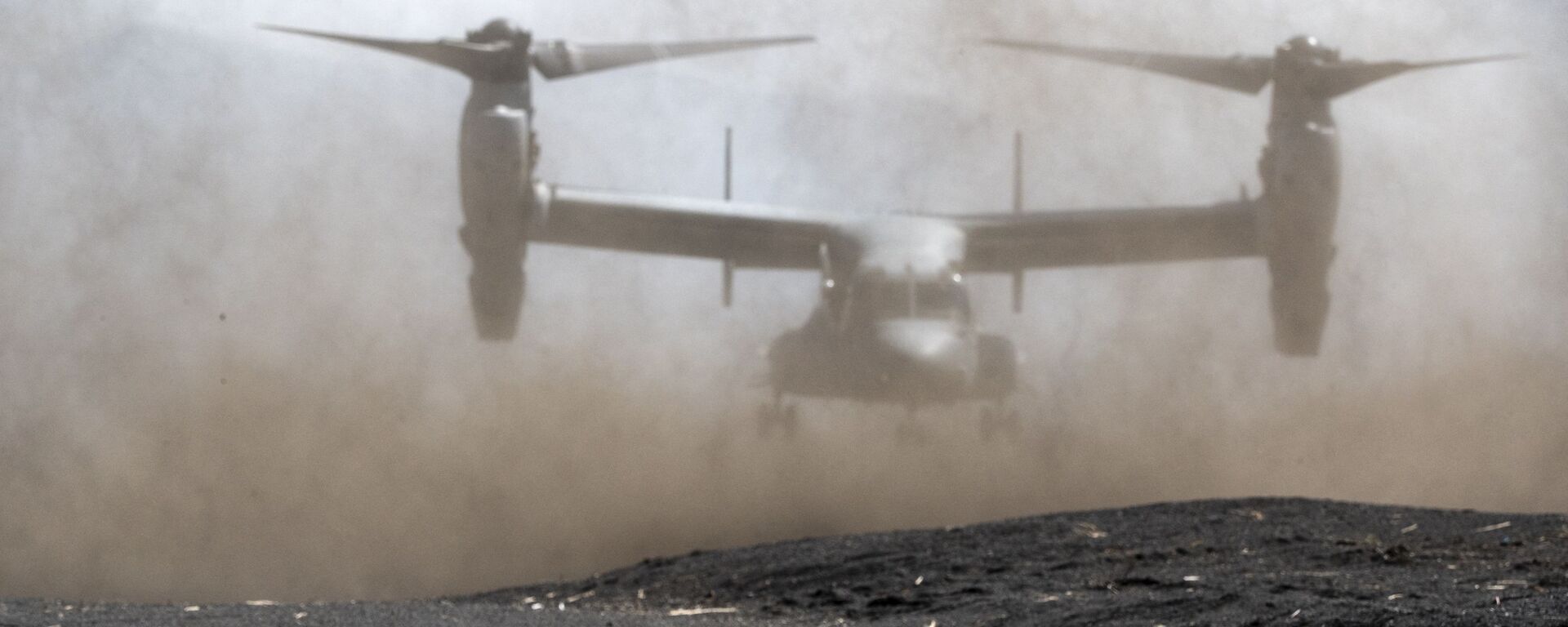 A member of the Japanese Self-Defense Force Amphibious Rapid Deployment Brigade holds position while a US Marine Corps MV-22 Osprey tilt-rotor aircraft takes off during a joint exercise with US Marine Corps personnel at the Higashifuji training area in Gotemba, Shizuoka Prefecture on March 15, 2022.  - Sputnik International, 1920, 09.12.2023