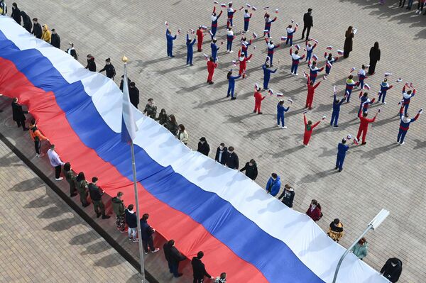 Participants in a flash mob dedicated to the 9th anniversary of the reunification of Crimea and Sevastopol with Russia at the site of the historical park &quot;Russia - My History&quot; in Rostov-on-Don. The activists unfurled a 30-meter Russian flag. - Sputnik International