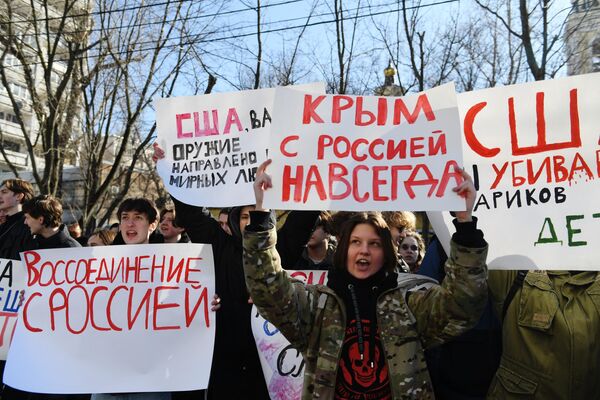 Participants of the &quot;Crimea with Russia Forever&quot; rally stand with placards outside the US Embassy in Moscow.   - Sputnik International