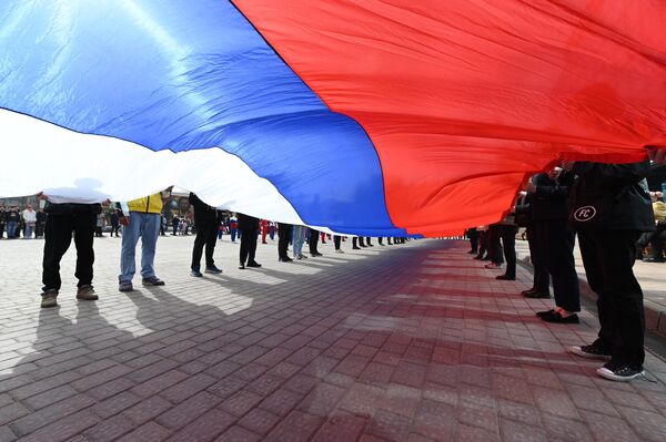 Participants of a flash mob dedicated to the 9th anniversary of the reunification of Crimea and Sevastopol with Russia at the site of the historical park &quot;Russia - My History&quot; in Rostov-on-Don. The activists unfurled a 30-meter Russian flag. - Sputnik International