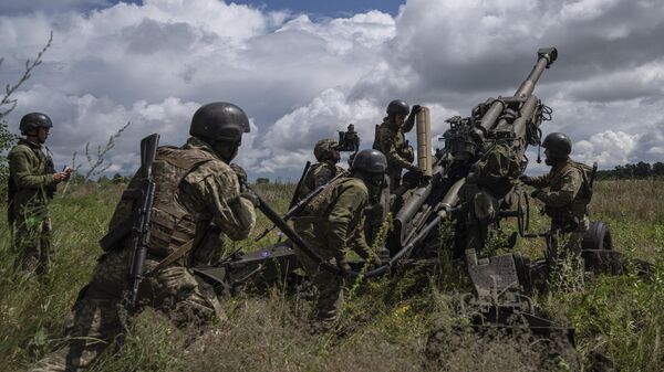 Ukrainian servicemen prepare to fire at Russian positions from a US-supplied M777 howitzer. - Sputnik International