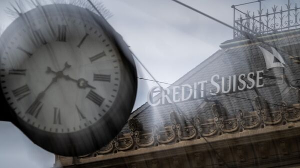 A sign of Credit Suisse is seen behind a clock at the headquarters of Switzerland's second-biggest bank in Zurich on March 18, 2023.  - Sputnik International