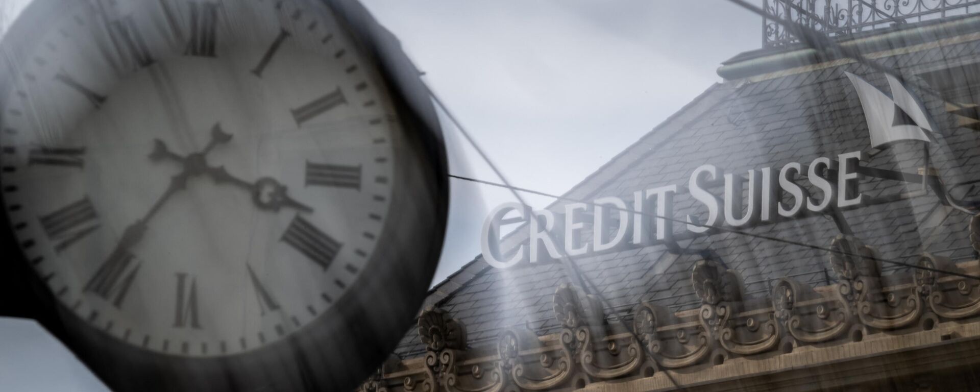 A sign of Credit Suisse is seen behind a clock at the headquarters of Switzerland's second-biggest bank in Zurich on March 18, 2023.  - Sputnik International, 1920, 19.03.2023