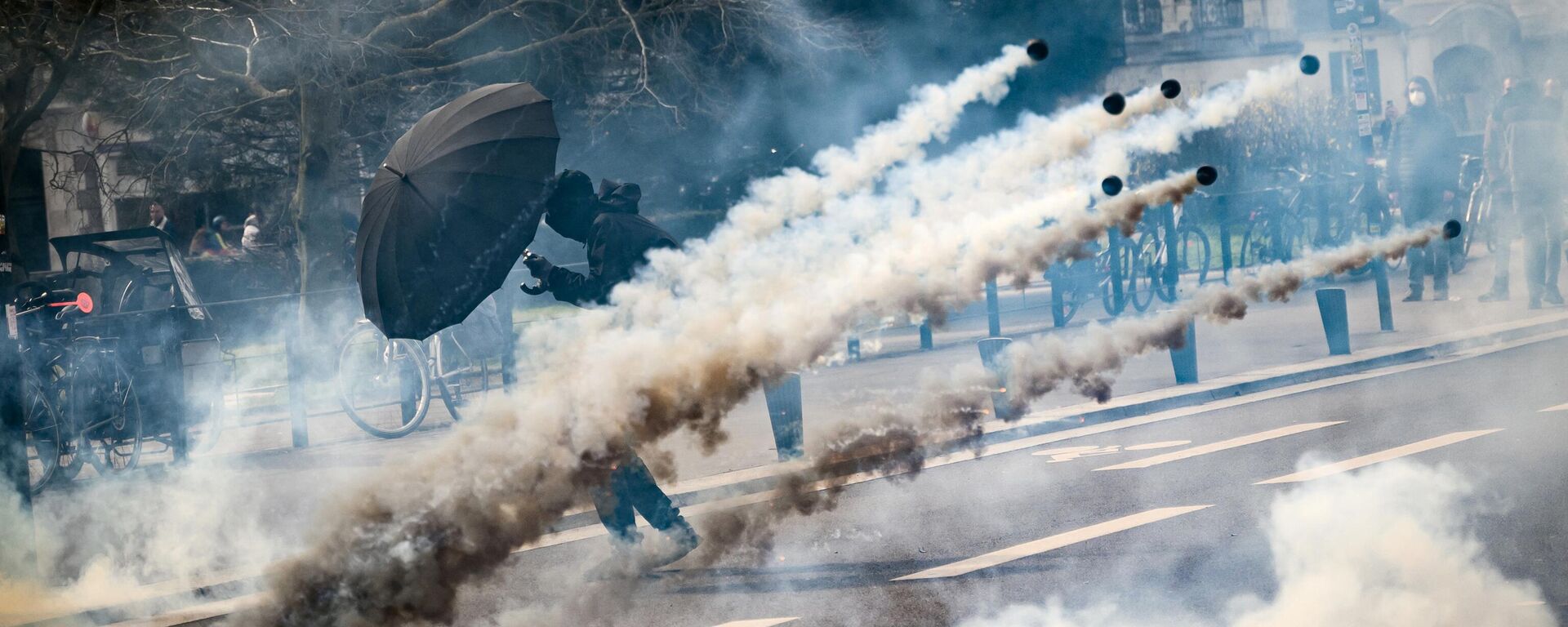 A protestor holds an umbrella to protect from teargas during a demonstration on the 8th day of strikes and protests across the country against the government's proposed pensions overhaul, in Nantes, on March 15, 2023.  - Sputnik International, 1920, 20.03.2023