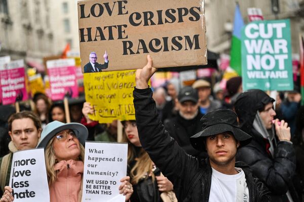 Protesters hold up placards as they take part in the Resist Racism March and Rally in central London on 18 March 2023, ahead of the United Nations anti-racism day on 21 March. - Sputnik International
