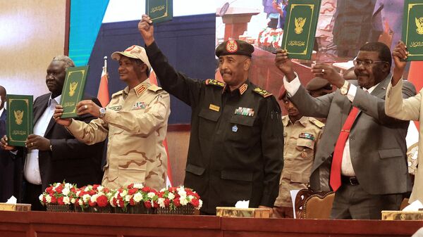 Sudan's Army chief Abdel Fattah al-Burhan (C R) and paramilitary commander Mohamed Hamdan Dagalo (C L) lift documents alongside civilian leaders following the signing of an initial deal aimed at ending a deep crisis caused by last year's military coup, in the capital Khartoum on December 5, 2022. - Sputnik International