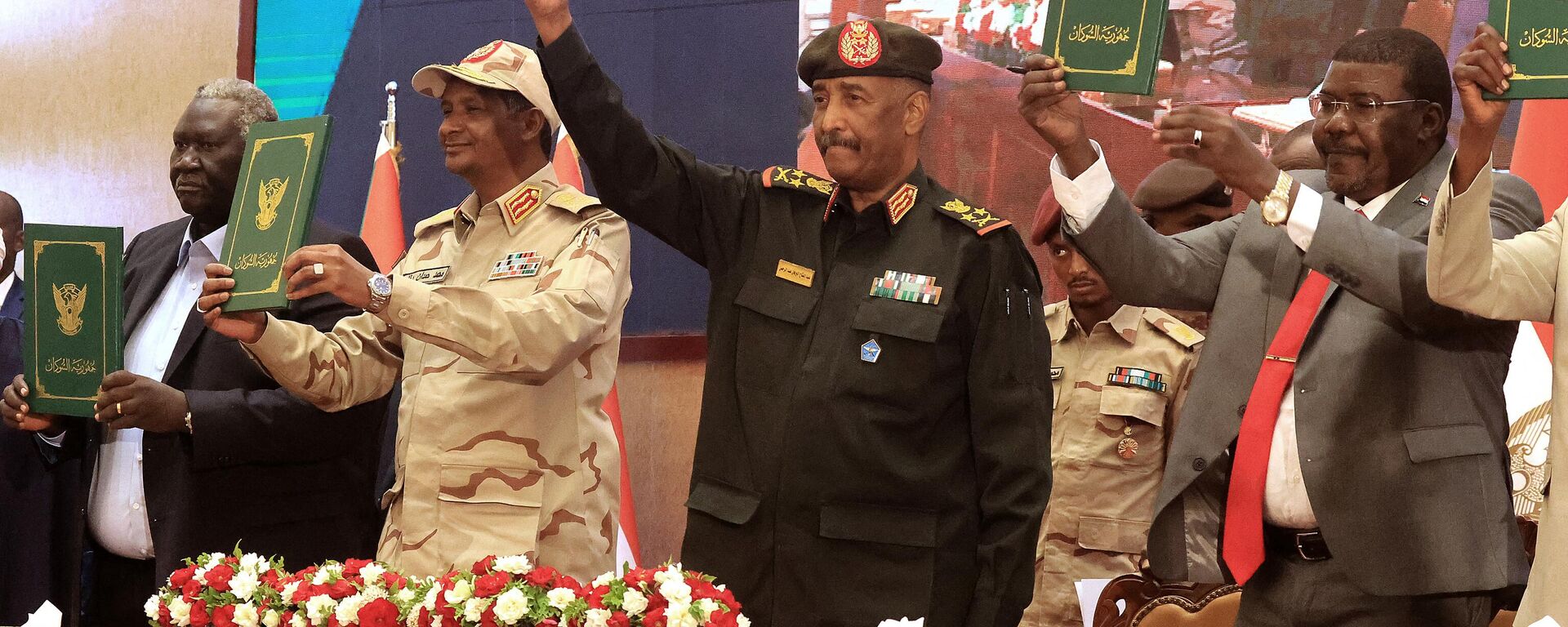 Sudan's Army chief Abdel Fattah al-Burhan (C R) and paramilitary commander Mohamed Hamdan Dagalo (C L) lift documents alongside civilian leaders following the signing of an initial deal aimed at ending a deep crisis caused by last year's military coup, in the capital Khartoum on December 5, 2022. - Sputnik International, 1920, 20.03.2023