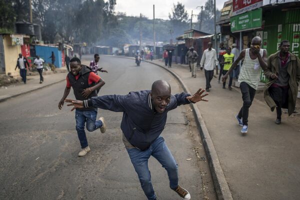 Protesters run from tear gas fired by police in the Kibera slum of Nairobi, Kenya Monday, March 20, 2023. - Sputnik International