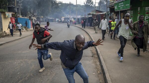 Protesters run from tear gas fired by police in the Kibera slum of Nairobi, Kenya Monday, March 20, 2023 - Sputnik International