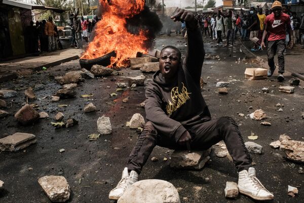 A protester gestures towards police officers during a mass rally called by the opposition leader Raila Odinga who claims the last Kenyan presidential election was stolen from him and blames the government for the hike of living costs in Kibera, Nairobi on March 20, 2023. - Sputnik International