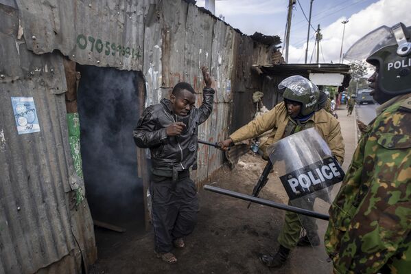 Police beat a protester who had hidden in a shack, after police threw a tear gas grenade inside to force him out, in the Kibera slum of Nairobi, Kenya Monday, March 20, 2023. - Sputnik International