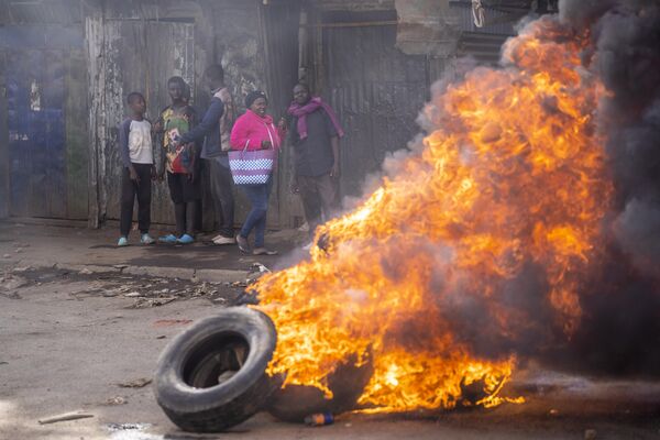 A passerby walks next to a burning barricade in the Kibera slum of Nairobi, Kenya Monday, March 20, 2023. - Sputnik International