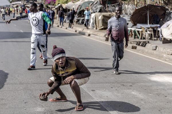 Opposition supporters carry stones and chant slogans demanding lower taxes and a reduced cost of living in Nairobi, Kenya, on March 20, 2023. - Sputnik International