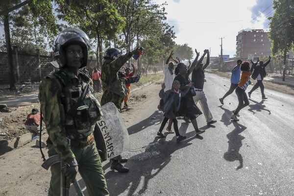 Civilians returning from work are directed to a holding area to be checked by police before being allowed to continue to their homes, during protests in the Mathare slum of Nairobi, Kenya Monday, March 20, 2023. - Sputnik International
